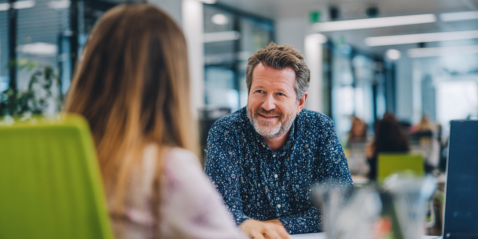 Management Diploma An empathetic manager conducting a one-on-one coaching session with a junior team member in a bright, modern UK office.